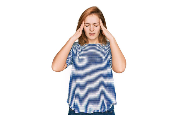 ストレスが原因で頭の痛みのために頭の上に手でカジュアルな服を着て若い白人女性。片頭痛.  - 写真・画像