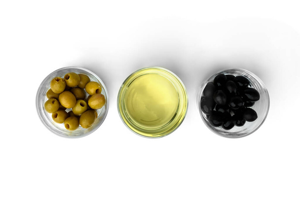 Green and black olives and olive oil isolated on white background. Top view. - Photo, Image