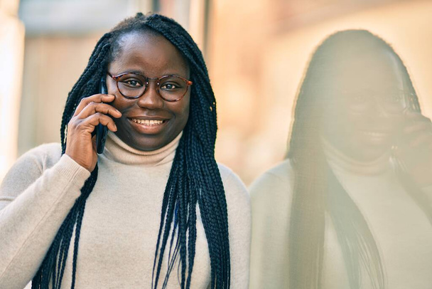 jong Afrikaans amerikaans vrouw praten op de smartphone in de stad. - Foto, afbeelding