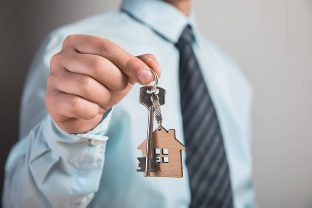 Evin anahtarlarını gri arkaplanda tutmak - Fotoğraf, Görsel