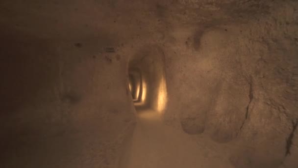 Yeraltı şehirlerinin odalarını birbirine bağlayan uzun bir koridor. Yeraltı sığınma evi, kiler kiler, drenaj kanalları mağaranın içindeki dar yol, taş devri, tarih öncesi neolitik ev arkeolojisi 4K - Video, Çekim