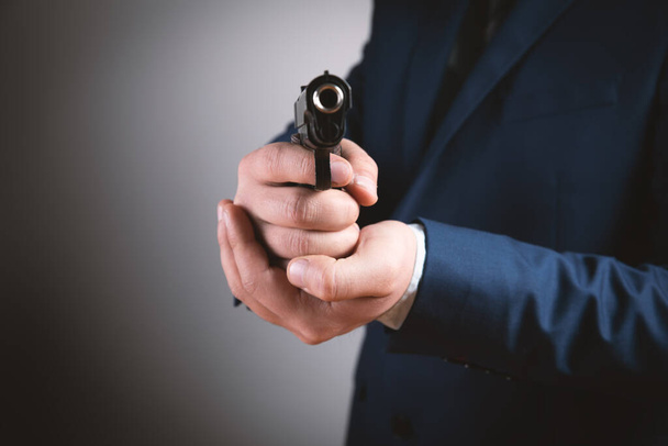 um homem segurando uma pistola preta em sua mão ameaçando - Foto, Imagem
