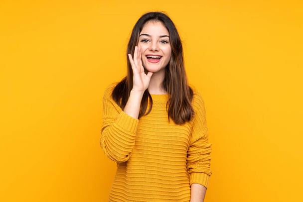 Young caucasian woman isolated on yellow background shouting with mouth wide open - Photo, Image