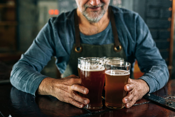 barman serving lager in bar - Foto, afbeelding