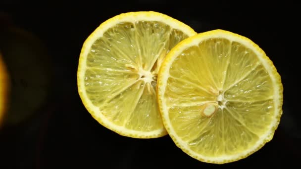 Несколько ломтиков лимона на черном фоне - Кадры, видео