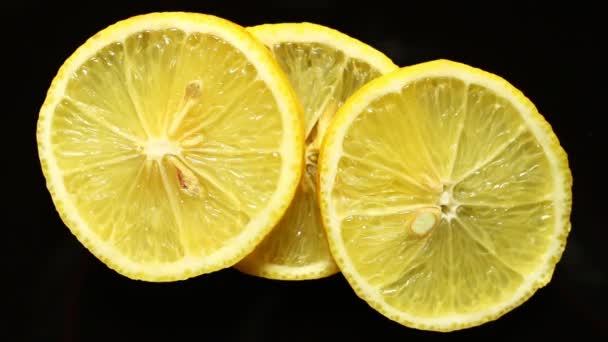 Hand puts a piece of lemon on black background - Footage, Video