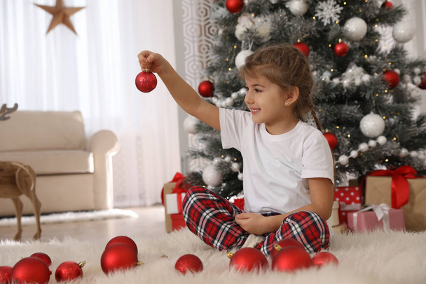Cute little girl with box of Christmas balls at home - Foto, imagen