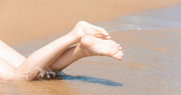 Female legs on the sandy seashore - Foto, Bild