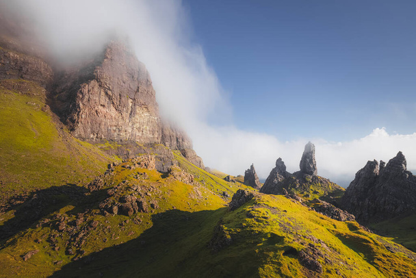 Un paisaje nebuloso, atmosférico y rocoso con una nube baja en el icónico pináculo de roca Old Man of Storr en la Isla de Skye en las tierras altas escocesas. - Foto, Imagen
