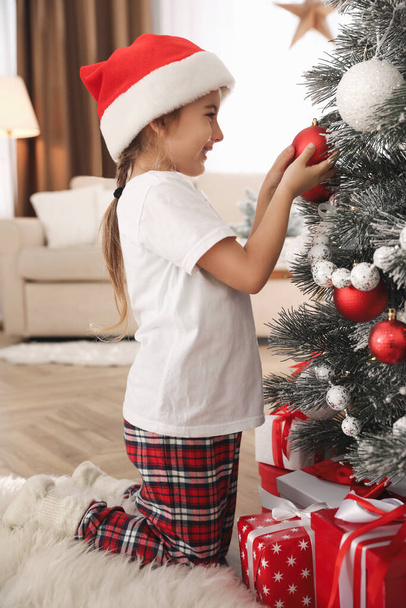 Cute little girl decorating Christmas tree at home - Foto, Imagem