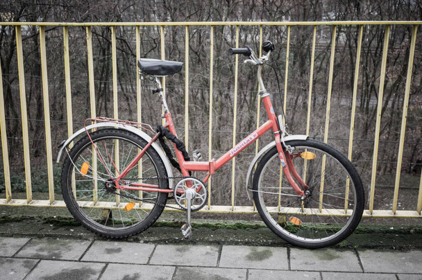 POZNAN, POLAND - Jan 12, 2018: Red bicycle locked on a metal barrier - Foto, immagini