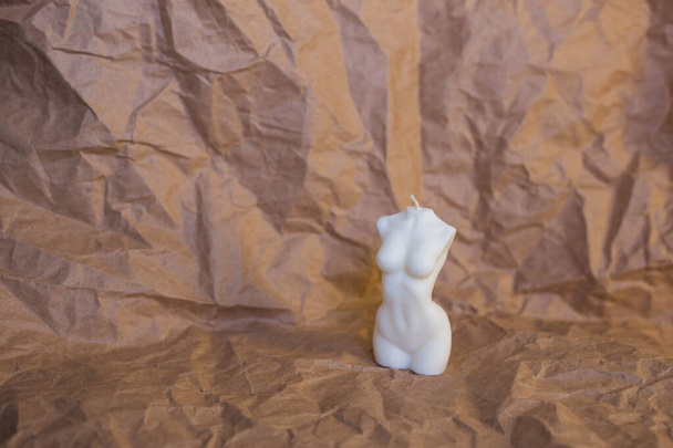 Vela branca na forma de uma figura feminina em um fundo de papel - Foto, Imagem