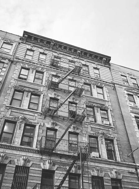 Schwarz-Weiß-Bild eines alten Gebäudes mit eiserner Feuerflucht, New York City, USA. - Foto, Bild