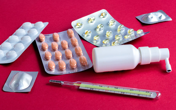 Spray, vitamines, plaquettes thermoformées de pilules, bouteille couchée près du mini panier flou - Photo, image
