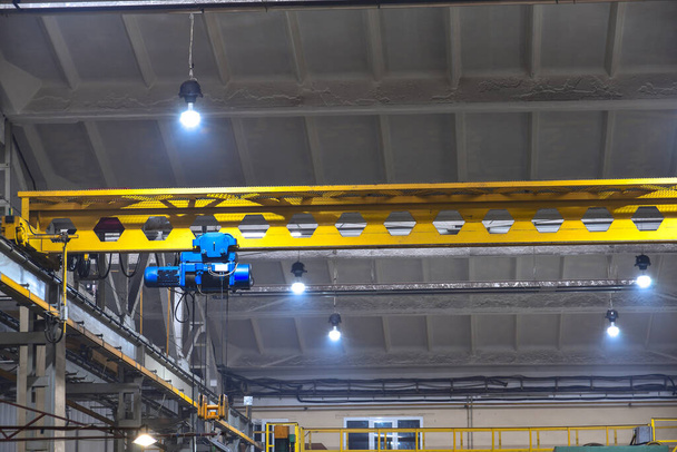 An overhead crane in a workshop at a factory, operated by a crane driver. - Photo, Image