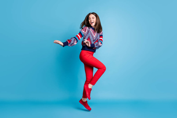 Full length profile side photo of young positive girl happy smile have fun jump up isolated over blue color background - Fotó, kép