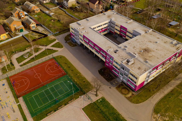 Vista aérea de la típica escuela ucraniana con nuevos campos deportivos. - Foto, imagen