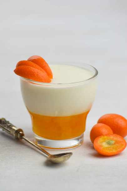 Вкусный итальянский десерт панна Котта с мандариновым желе на белом фоне. - Фото, изображение