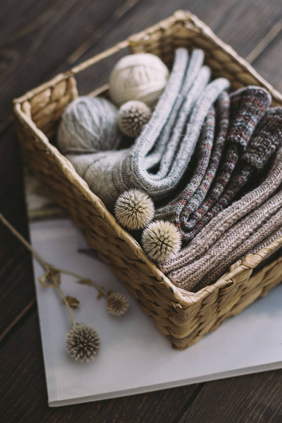Chaussettes à tricoter à la main avec des boules de fil dans un panier sur un fond en bois foncé. Concept pour la vie lente à la main et hygge.   - Photo, image