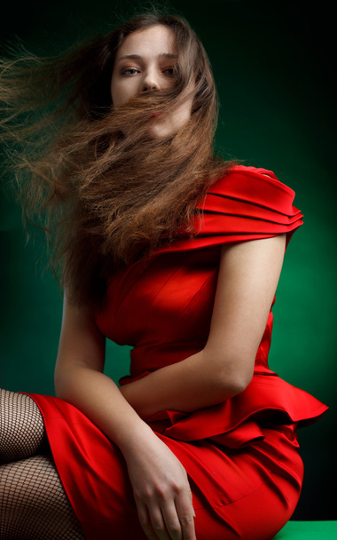 yeşil üzerinde kırmızı elbise ile şık kadın portresi - Fotoğraf, Görsel
