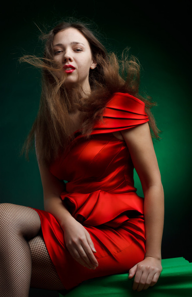 Portrait of fashionable woman with red dress over green - Zdjęcie, obraz