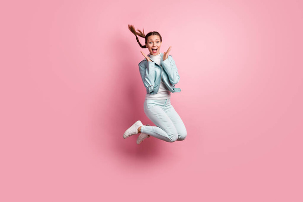 Full length photo portrait of amazed woman jumping up isolated on pastel pink colored background - Photo, image