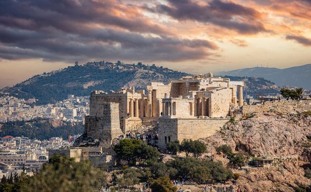 Atenas, Grecia. Acrópolis puerta propilea y monumento Agripa vista desde la colina Philopappos. Cielo nublado y colorido al sol - Foto, Imagen