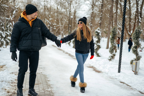Young happy couple in love having a walk in a winter park - Foto, Imagem