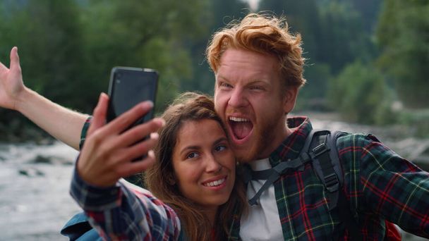 Muž a žena berou Selfie na telefon. Přátelé dělat legrační obličeje na kameru - Fotografie, Obrázek