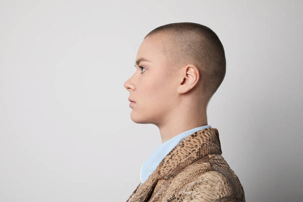Side portrait of a beautiful bald woman posing over white background. - Foto, imagen