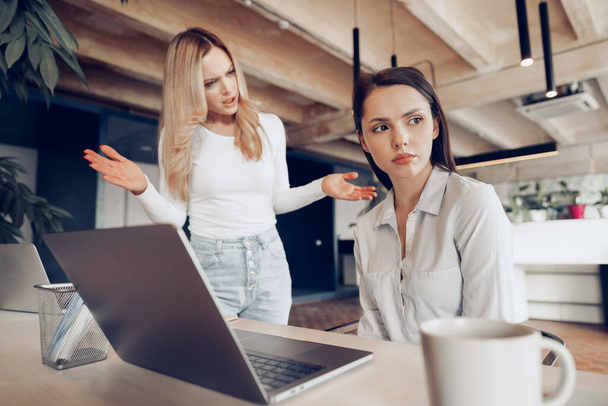 Young female boss scolding her female subordinate for bad work results - Fotoğraf, Görsel