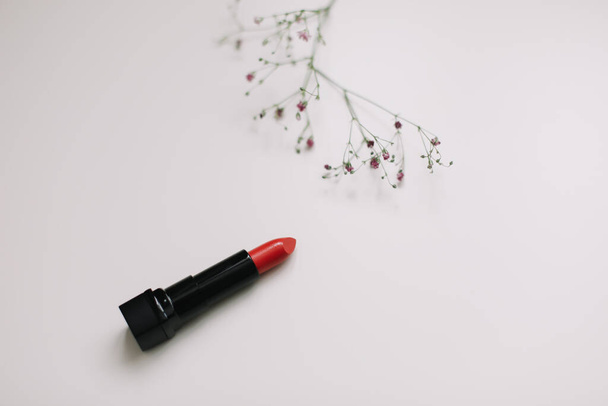 Lipstick with beautiful flowers on white background - Foto, afbeelding