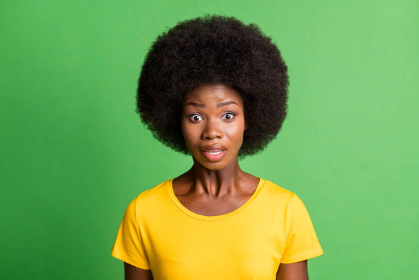 ショックを受けた若いアフロアメリカ人女性の写真は、緑色の背景に隔離された黄色のTシャツを着ている - 写真・画像