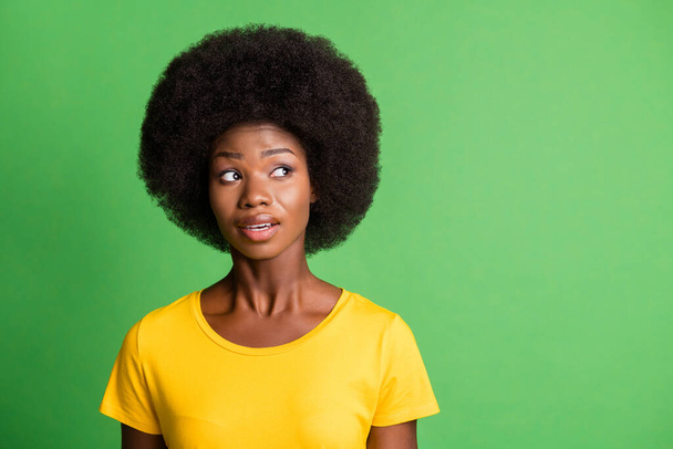 Photo of dreamy minded young dark skin woman look empty space wonder isolated on green color background - Valokuva, kuva