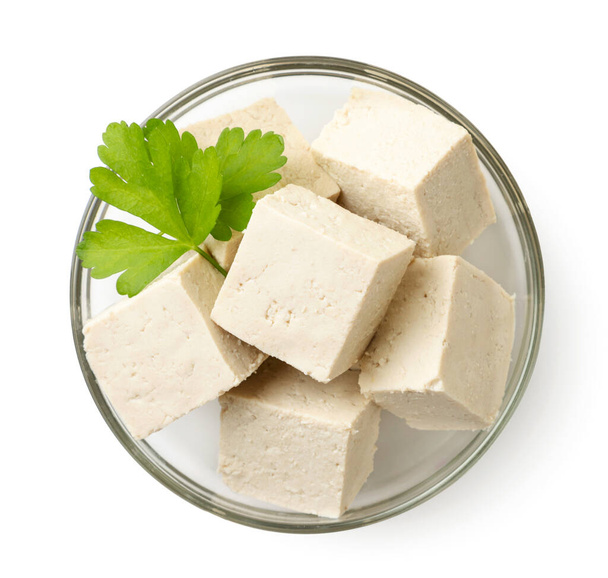 Queso de tofu cortado en cubitos con perejil en un plato de primer plano sobre un fondo blanco, aislado. La vista desde arriba - Foto, Imagen