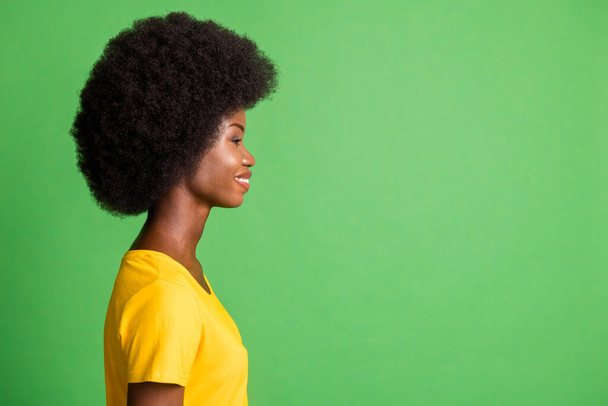 Side profile photo portrait of curly woman looking copyspace smiling happy isolated on bright green color background - Fotó, kép