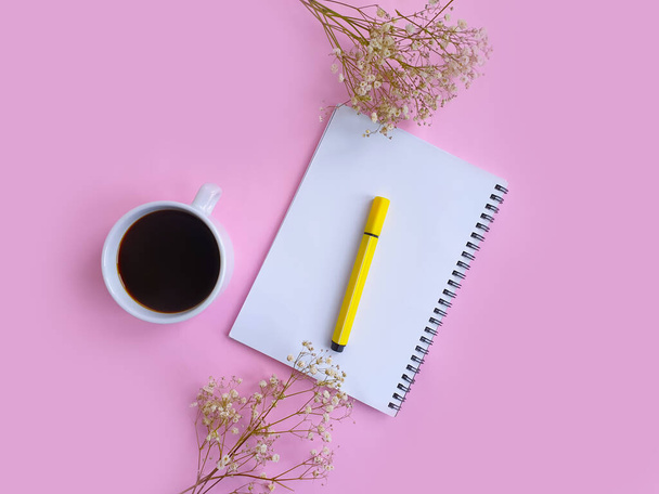 notebook, cup of coffee, gypsophila flower on colored background - Photo, Image