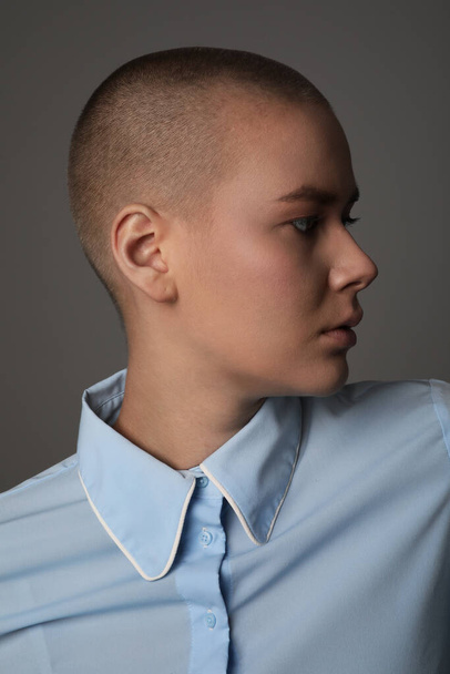 Portrait of a young bald woman wearing blue clothes and looking aside. - Foto, Imagem