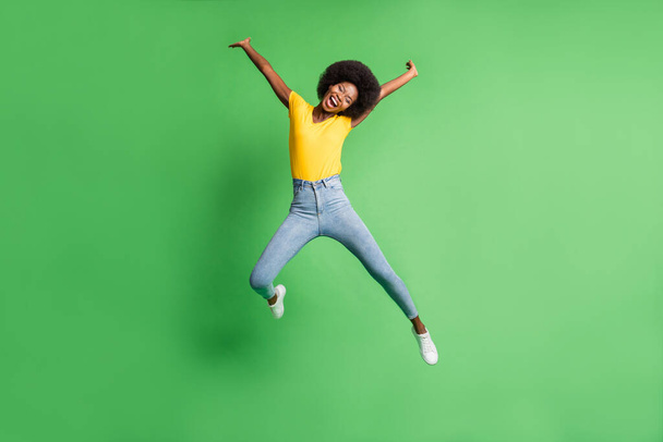 Full length body size photo of jumping girl careless laughing cheerful isolated on bright green color background - Фото, изображение