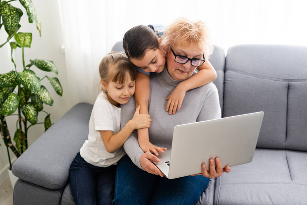 Grandmother with granddaughters use a computer - Photo, Image