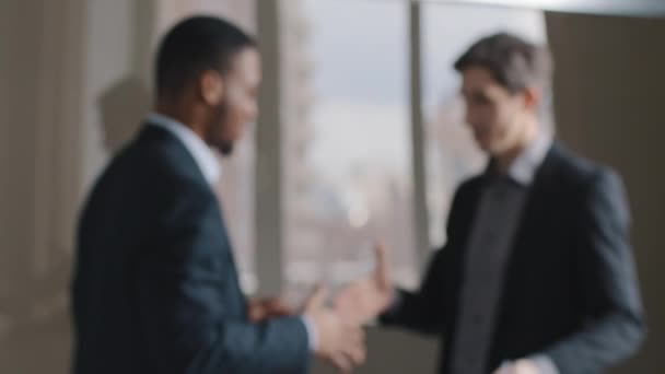 Hämärtynyt kaksi monirotuinen monikansallinen liikemiehet puhuvat toimistossa kättely, keskeneräinen näkymä mies siluetit afro amerikkalainen mies ja valkoihoinen johtaja tehdä sopimuksen liiton kädenpuristus, tiimityö - Materiaali, video
