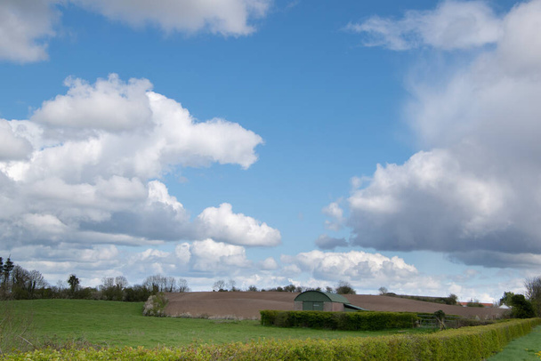 Αγροτική γη, θέα της γεωργικής γης με χαμηλό συννεφιασμένο ουρανό.αγροτικό τοπίο. - Φωτογραφία, εικόνα