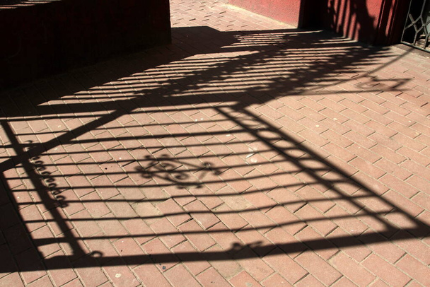 a kerítés árnyéka az aszfalton - Fotó, kép