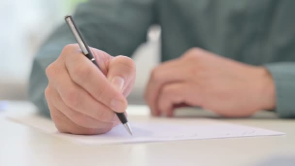 Close-up van handen van de middelbare leeftijd Man schrijven op papier  - Video
