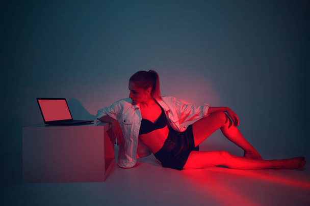 Modern Girl with laptop, tablet computer. Free creativity. Young blogger in Home office. Colored Neon light - Fotó, kép