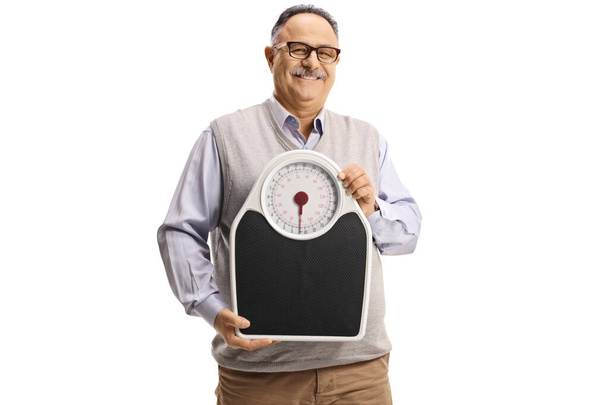 Happy mature man holding a weight scale isolated on white background - Φωτογραφία, εικόνα