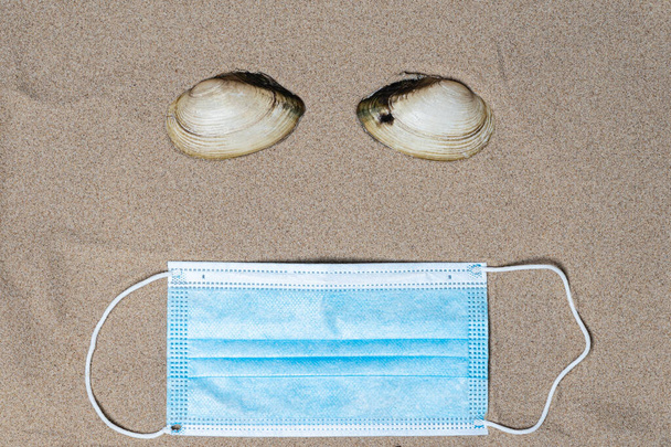 Conchas marinas y máscara médica, vista superior, hay un lugar para el texto. Concepto de vacaciones de verano junto al mar - Foto, Imagen