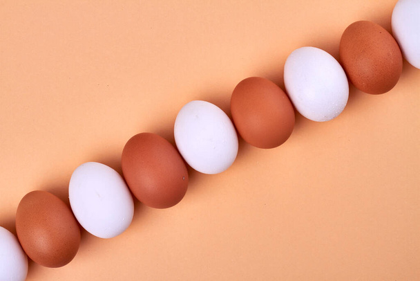 Línea hecha de huevos blancos y marrones. - Foto, Imagen