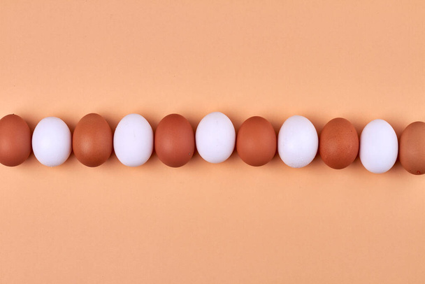 Row of white and brown chicken eggs. - Φωτογραφία, εικόνα