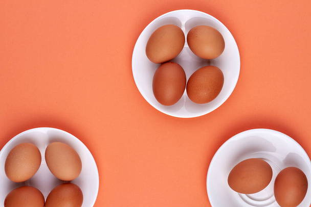 Top view brown eggs on white plates. - Zdjęcie, obraz